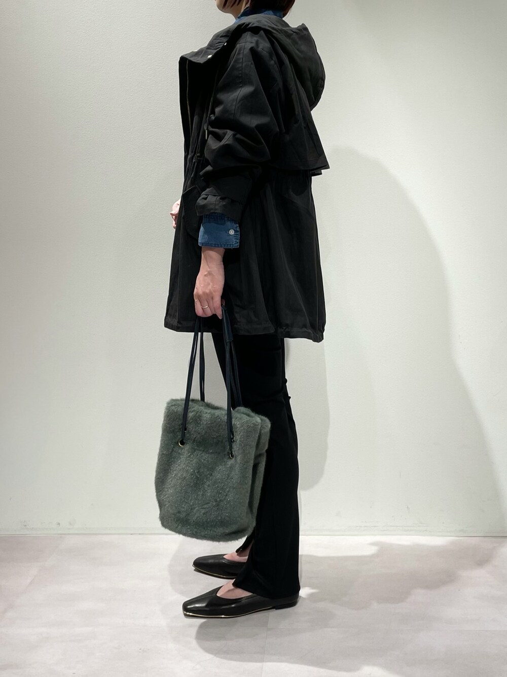 ブラック系のその他パンツ、ブルー系のシャツ/ブラウス、グリーン系のショルダーバッグを着用したレディースの秋コーディネートの2枚目の写真