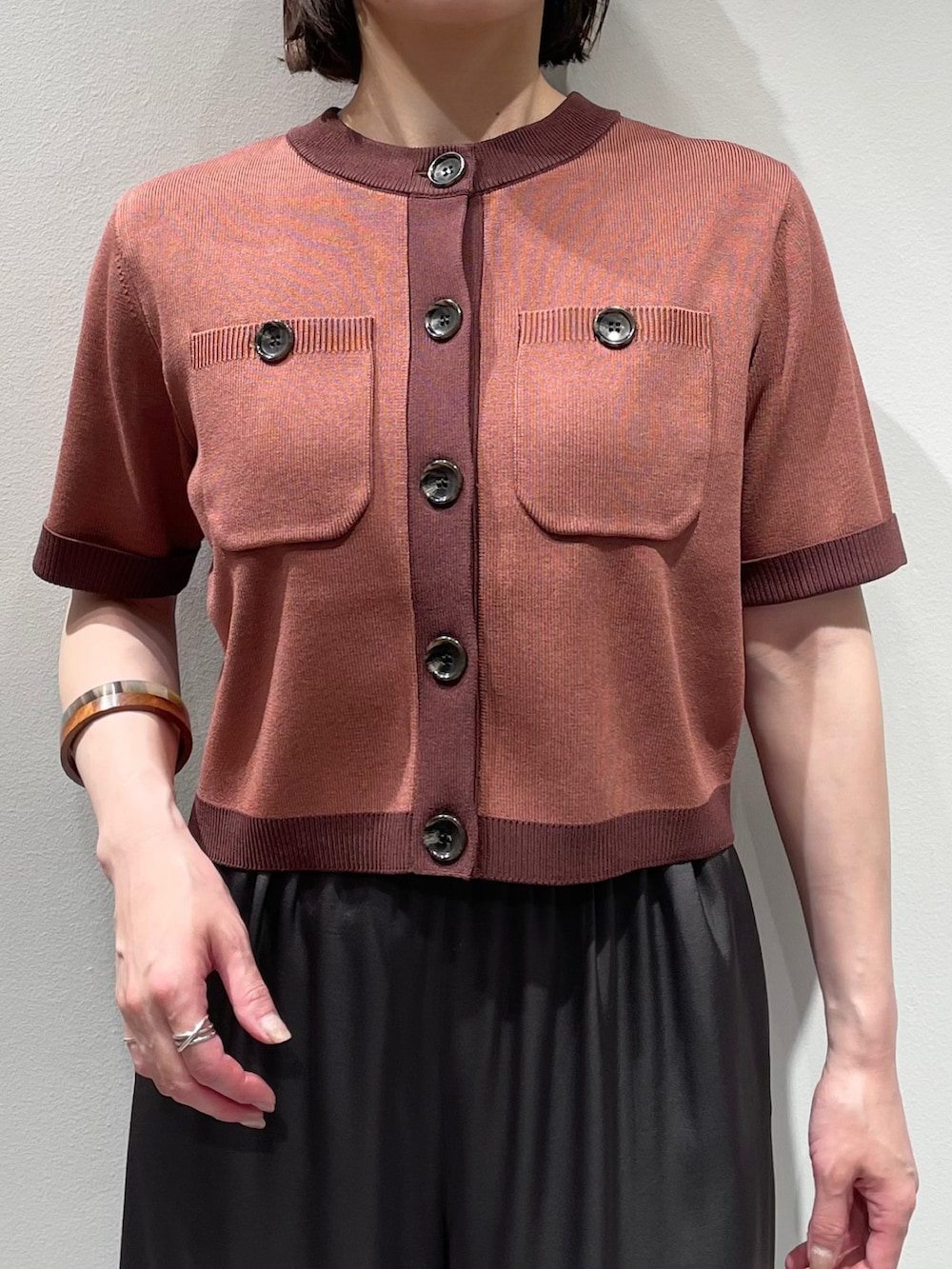 グレー系のその他パンツ、ピンク系のカーディガン/ボレロ、ブラウン系のネックレスを着用したレディースの夏コーディネートの4枚目の写真