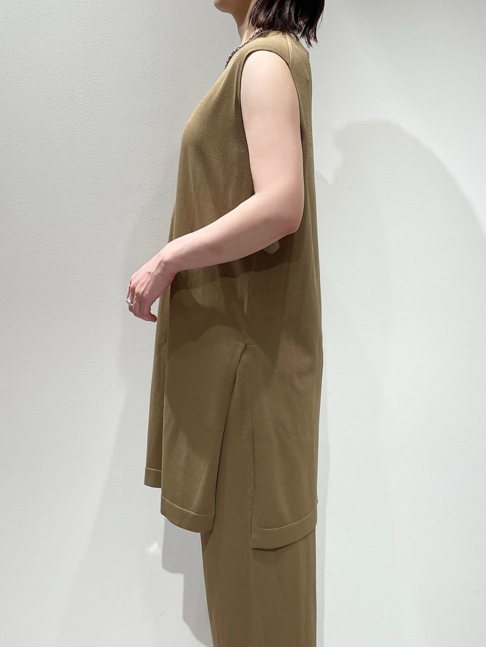 ベージュ系のその他パンツ、ベージュ系のニット/セーター、シルバー系のネックレスを着用したレディースの夏コーディネートの5枚目の写真