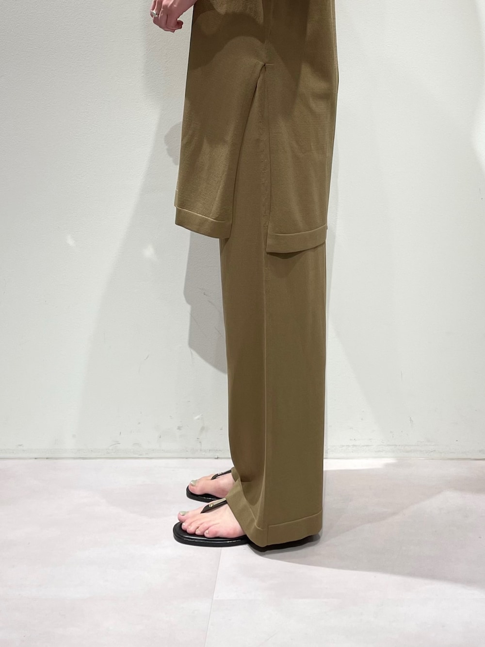 ベージュ系のその他パンツ、ベージュ系のニット/セーター、シルバー系のネックレスを着用したレディースの夏コーディネートの8枚目の写真