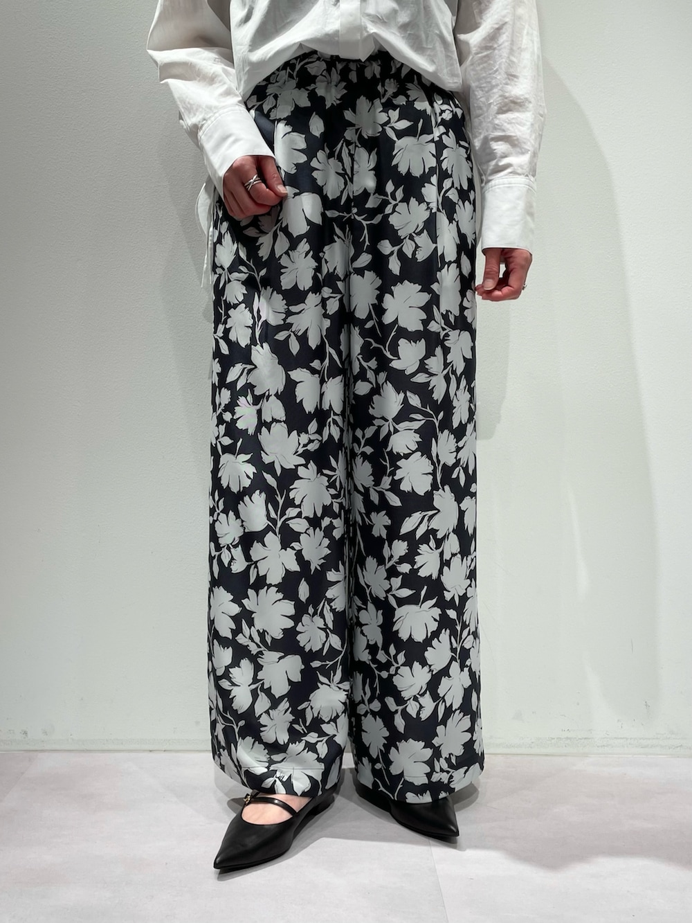 グレー系のその他パンツ、ホワイト系のニット/セーター、ゴールド系のネックレスを着用したレディースの冬コーディネートの9枚目の写真