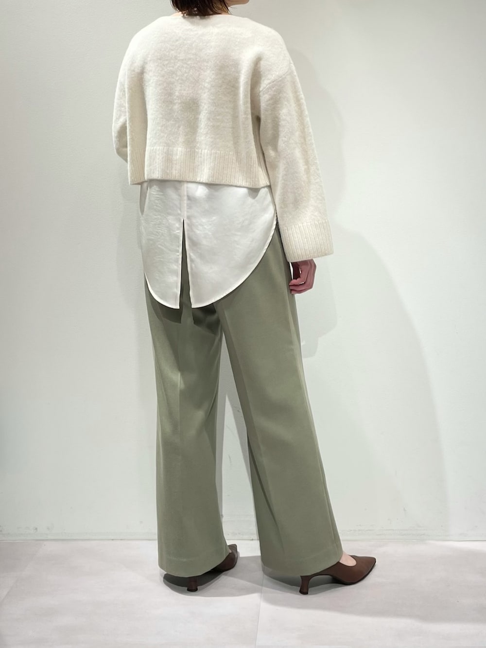 グリーン系のその他パンツ、ホワイト系のニット/セーター、ホワイト系のタンクトップを着用したレディースの冬コーディネートの9枚目の写真