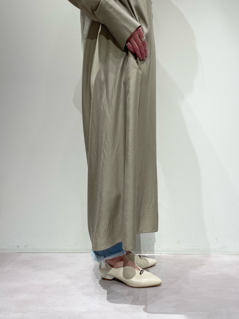 ベージュ系のワンピース、ブルー系のデニムパンツを着用したレディースの春コーディネートの8枚目の写真