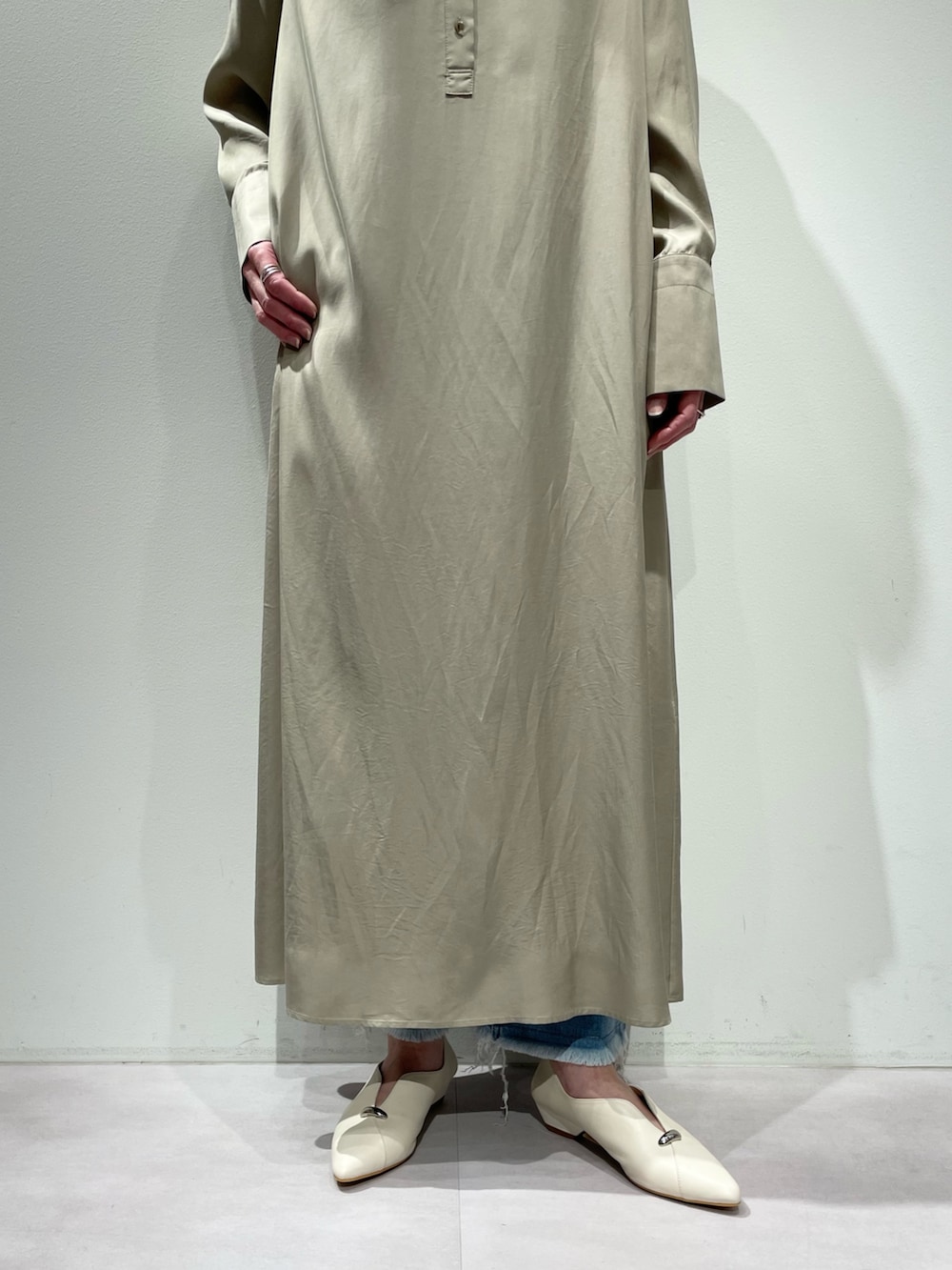 ベージュ系のワンピース、ブルー系のデニムパンツを着用したレディースの春コーディネートの7枚目の写真