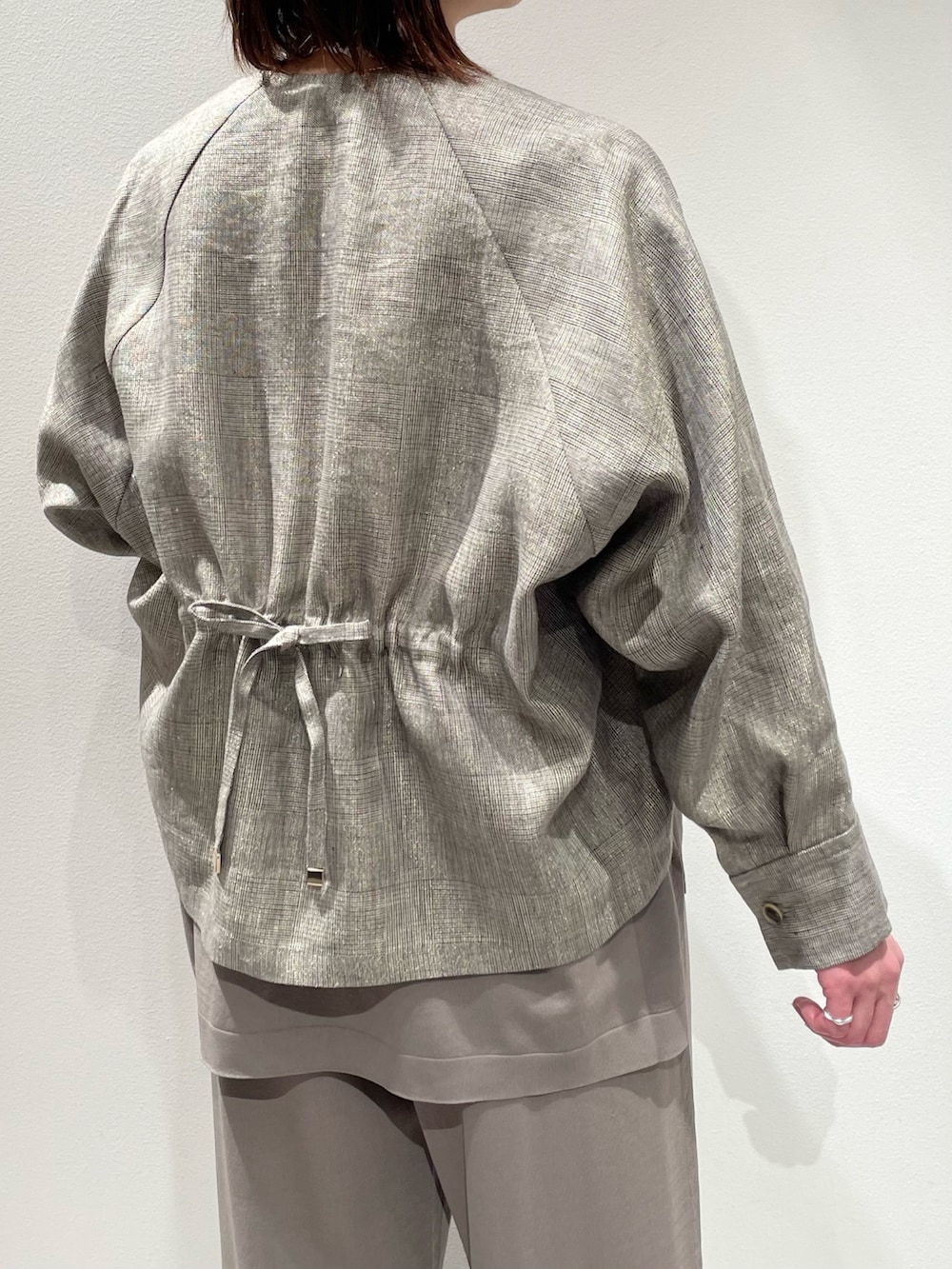 グレー系のニット/セーター、グレー系のその他パンツ、ベージュ系のブルゾンを着用したレディースの春コーディネートの6枚目の写真