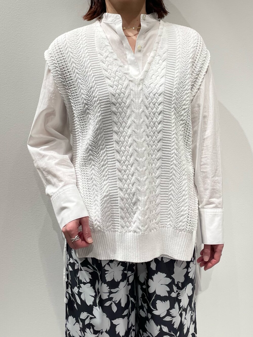 グレー系のその他パンツ、ホワイト系のニット/セーター、ゴールド系のネックレスを着用したレディースの冬コーディネートの4枚目の写真