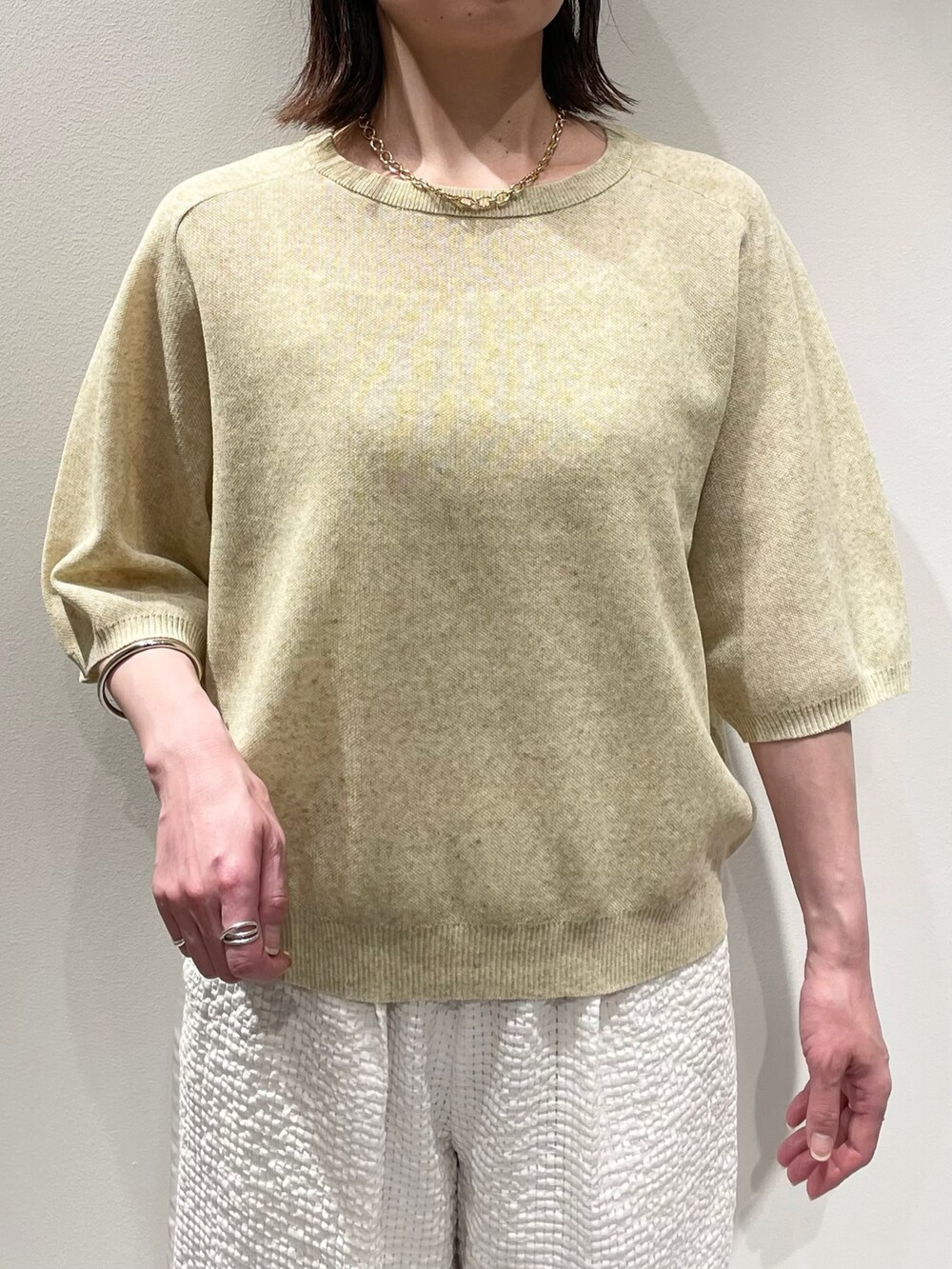 イエロー系のニット/セーター、ホワイト系のその他パンツ、ブラウン系のサンダルを着用したレディースの夏コーディネートの4枚目の写真