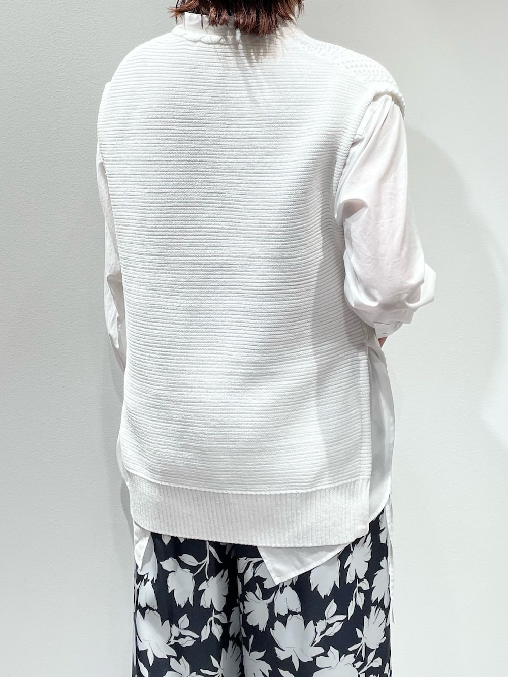 グレー系のその他パンツ、ホワイト系のニット/セーター、ゴールド系のネックレスを着用したレディースの冬コーディネートの6枚目の写真