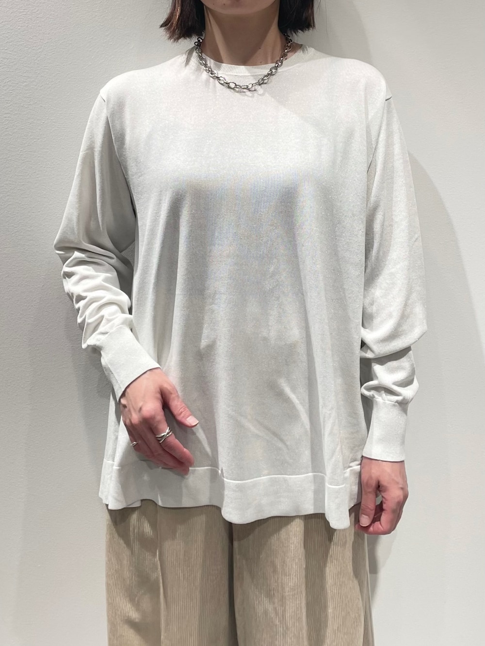 ベージュ系のその他パンツ、ホワイト系のニット/セーター、シルバー系のネックレスを着用したレディースの秋コーディネートの4枚目の写真