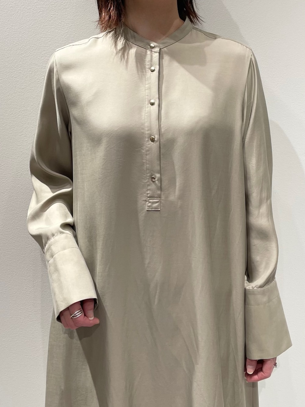 ベージュ系のワンピース、ブルー系のデニムパンツを着用したレディースの春コーディネートの4枚目の写真