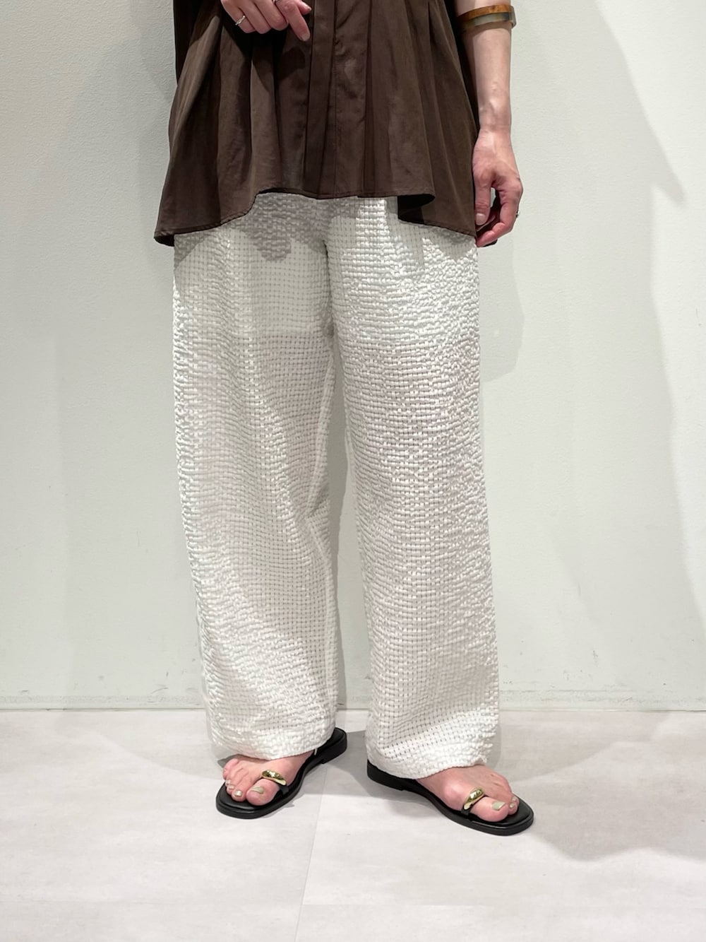 ブラウン系のシャツ/ブラウス、ホワイト系のその他パンツ、ブラウン系のネックレスを着用したレディースの夏コーディネートの7枚目の写真