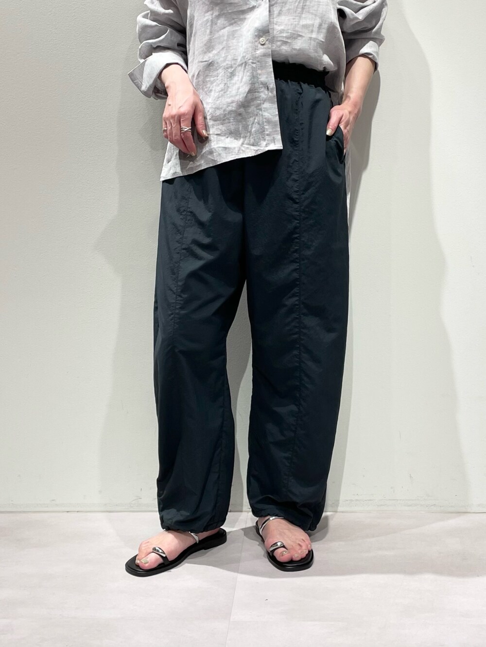 ホワイト系のニット/セーター、パープル系のシャツ/ブラウス、グレー系のその他パンツを着用したレディースの春コーディネートの7枚目の写真
