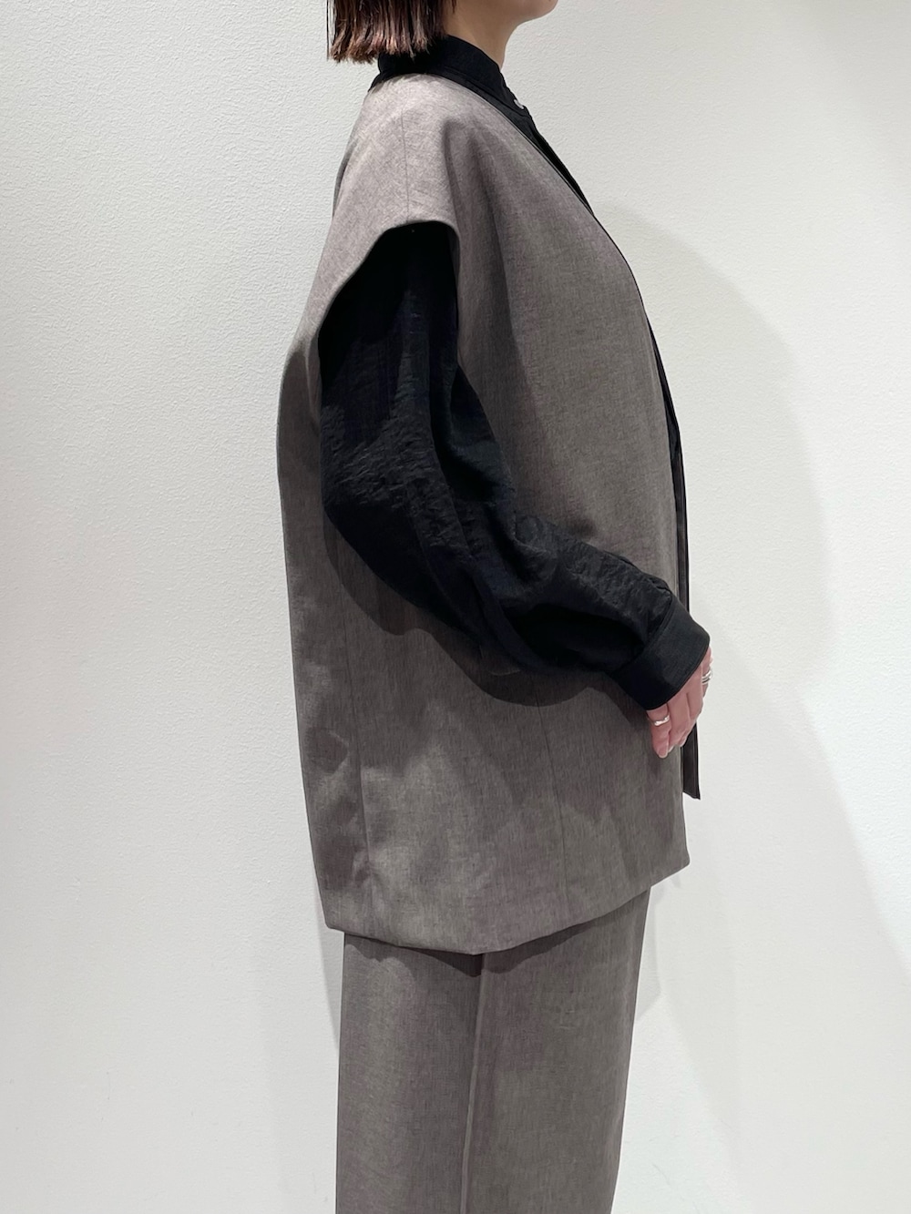 グレー系のその他パンツ、グレー系のベスト、ブラック系のシャツ/ブラウスを着用したレディースの秋コーディネートの5枚目の写真