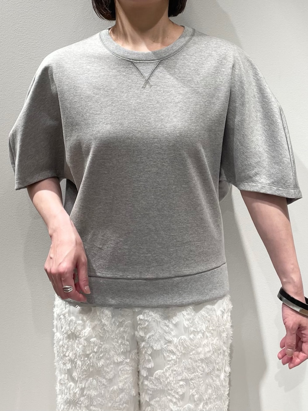 グレー系のスウェット、ホワイト系のその他パンツ、ブラック系のネックレスを着用したレディースの夏コーディネートの4枚目の写真