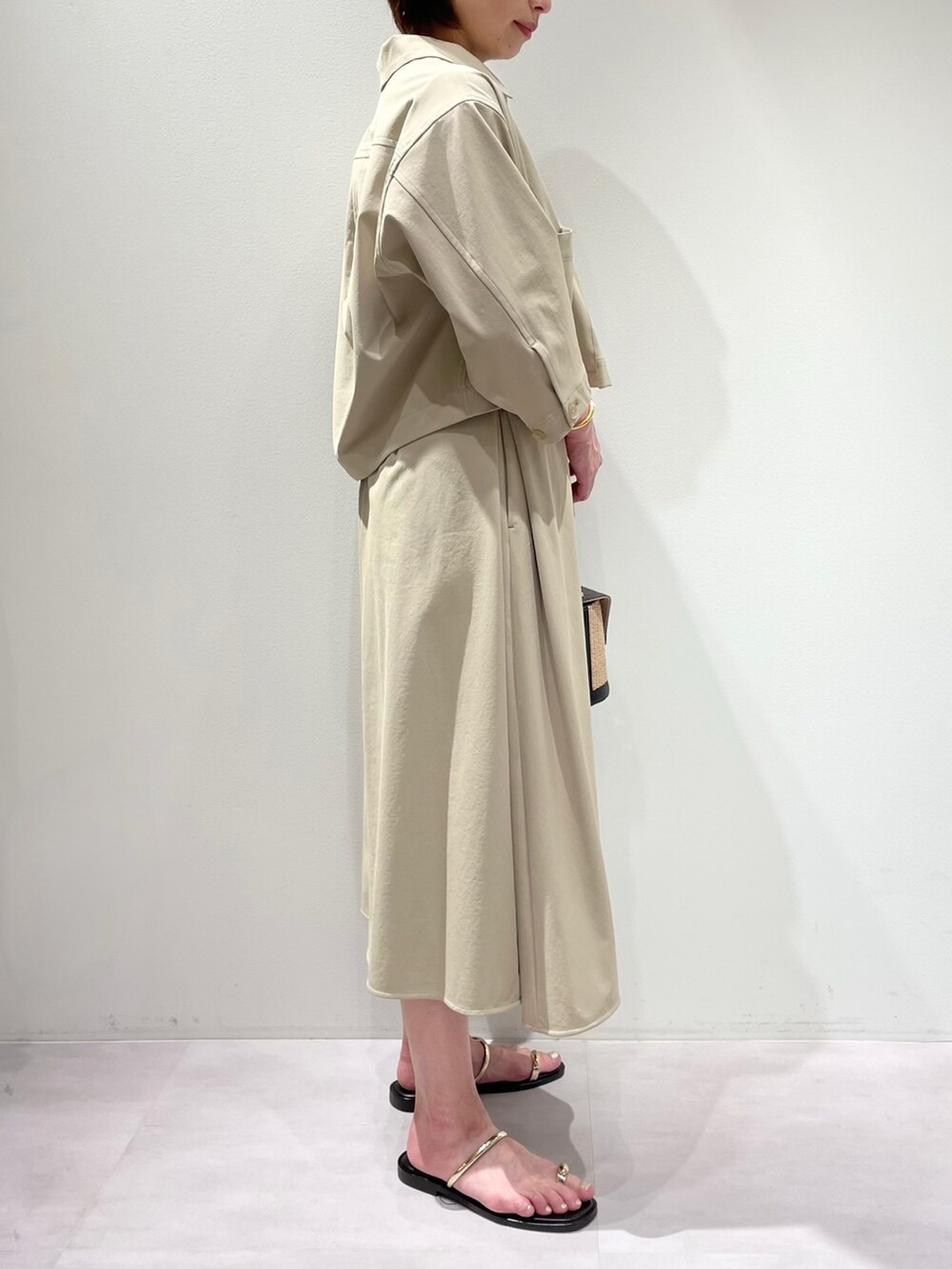 ベージュ系のトートバッグ、ベージュ系のワンピース、ベージュ系のブルゾンを着用したレディースの春コーディネートの3枚目の写真