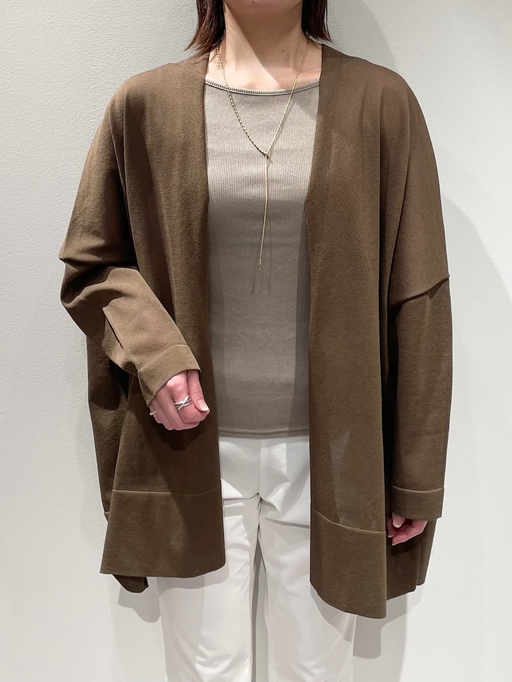 グリーン系のシャツ/ブラウス、ベージュ系のタンクトップ、ホワイト系のその他パンツを着用したレディースの春コーディネートの4枚目の写真