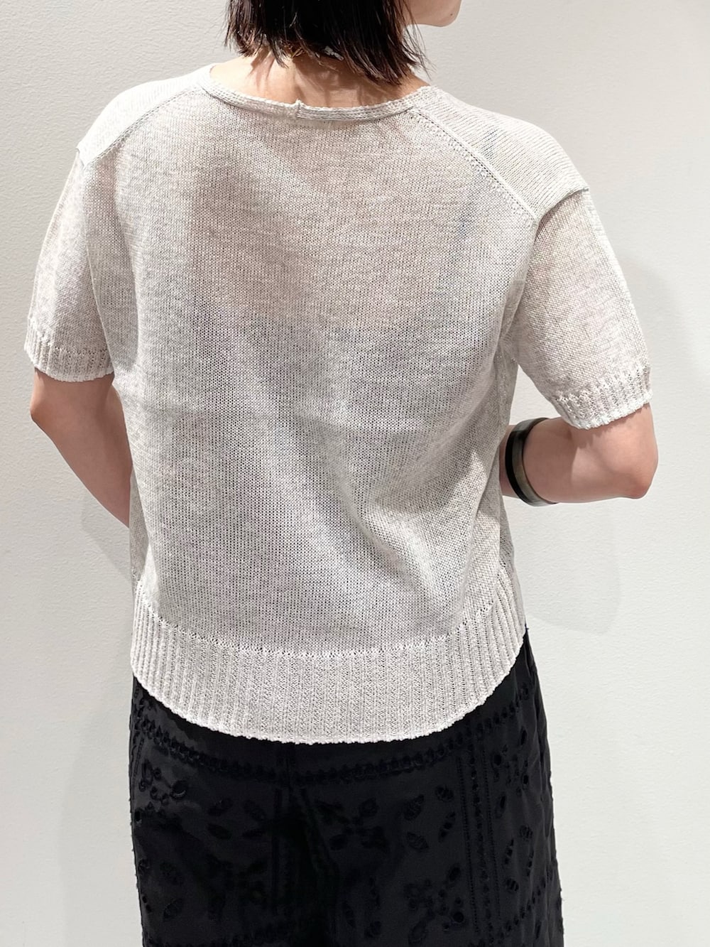 ブラック系のその他パンツ、ホワイト系のニット/セーター、ホワイト系のネックレスを着用したレディースの春コーディネートの6枚目の写真