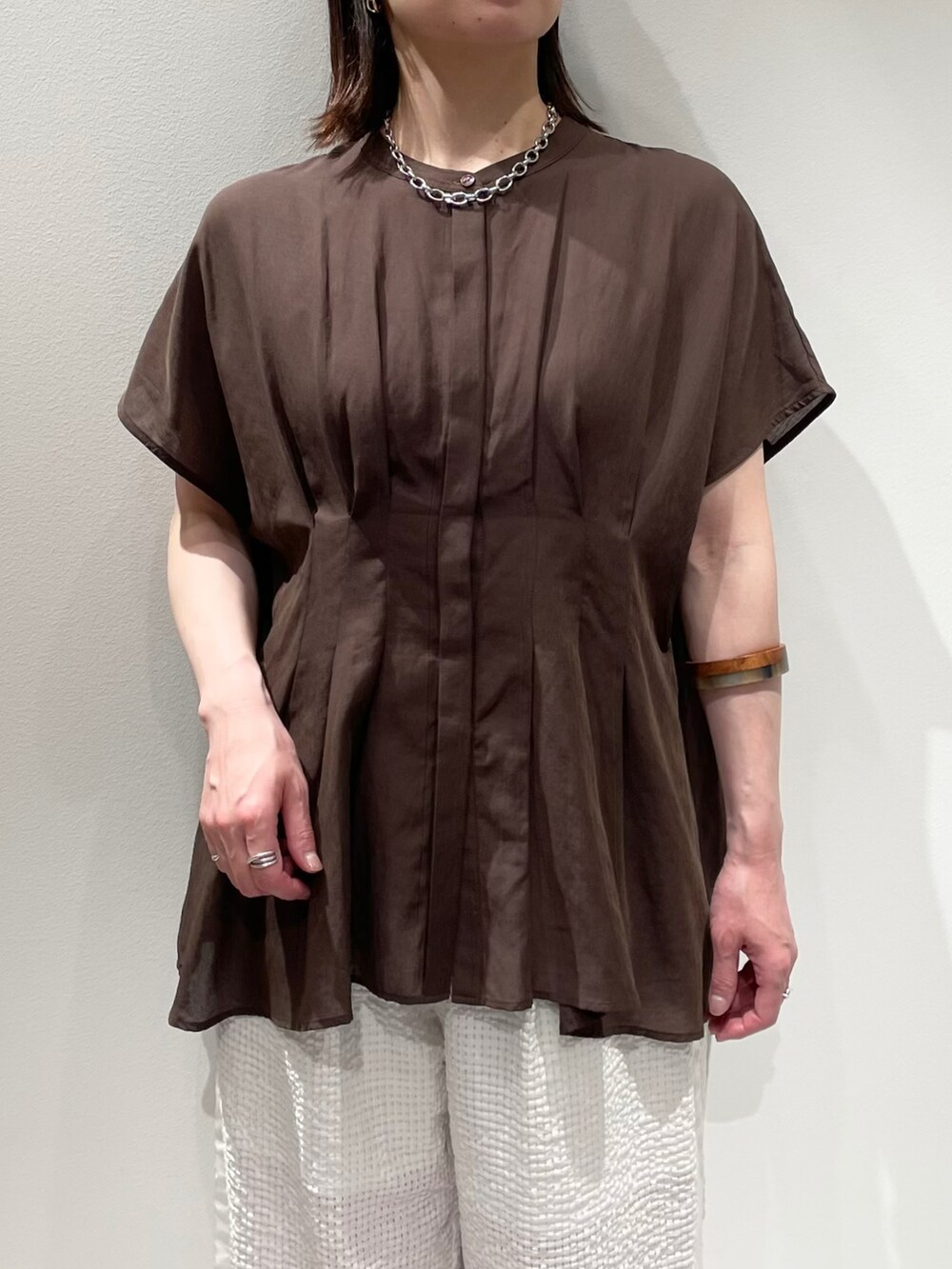 ブラウン系のシャツ/ブラウス、ホワイト系のその他パンツ、ブラウン系のネックレスを着用したレディースの夏コーディネートの4枚目の写真