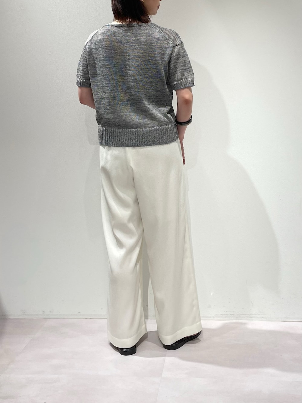 グレー系のニット/セーター、ホワイト系のその他パンツ、ブラウン系のサンダルを着用したレディースの夏コーディネートの3枚目の写真