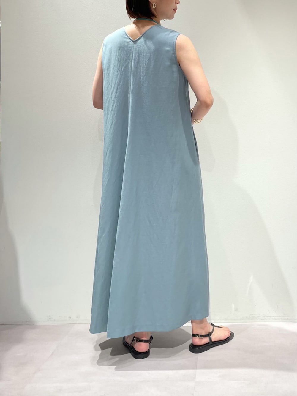 ブラウン系のサンダル、ブルー系のワンピース、ブラック系のショルダーバッグを着用したレディースの夏コーディネートの6枚目の写真