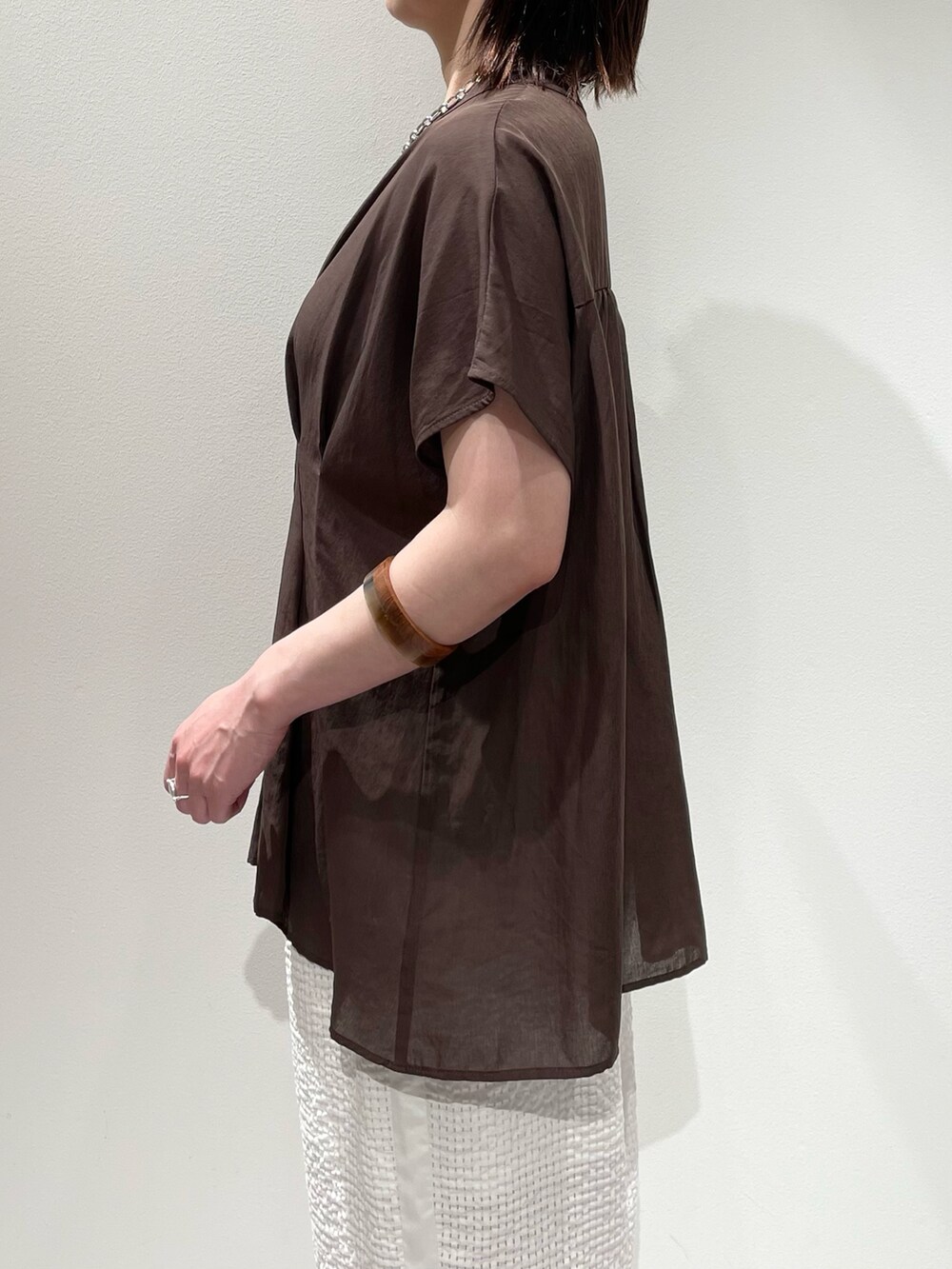 ブラウン系のシャツ/ブラウス、ホワイト系のその他パンツ、ブラウン系のネックレスを着用したレディースの夏コーディネートの5枚目の写真