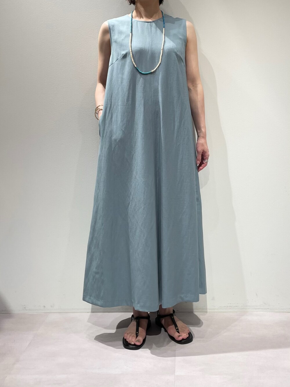 ブラウン系のサンダル、ブルー系のワンピース、ブラック系のショルダーバッグを着用したレディースの夏コーディネートの4枚目の写真