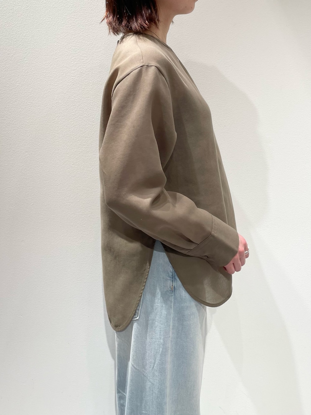 グリーン系のシャツ/ブラウス、ブルー系のデニムパンツ、ブラウン系のベルトを着用したレディースの冬コーディネートの5枚目の写真