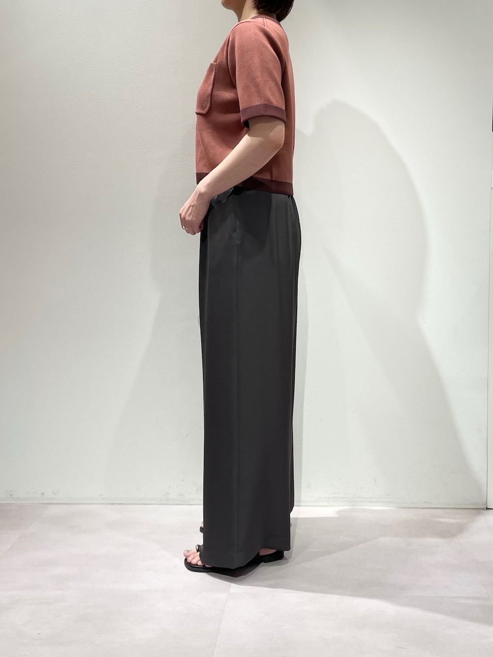 グレー系のその他パンツ、ピンク系のカーディガン/ボレロ、ブラウン系のネックレスを着用したレディースの夏コーディネートの3枚目の写真