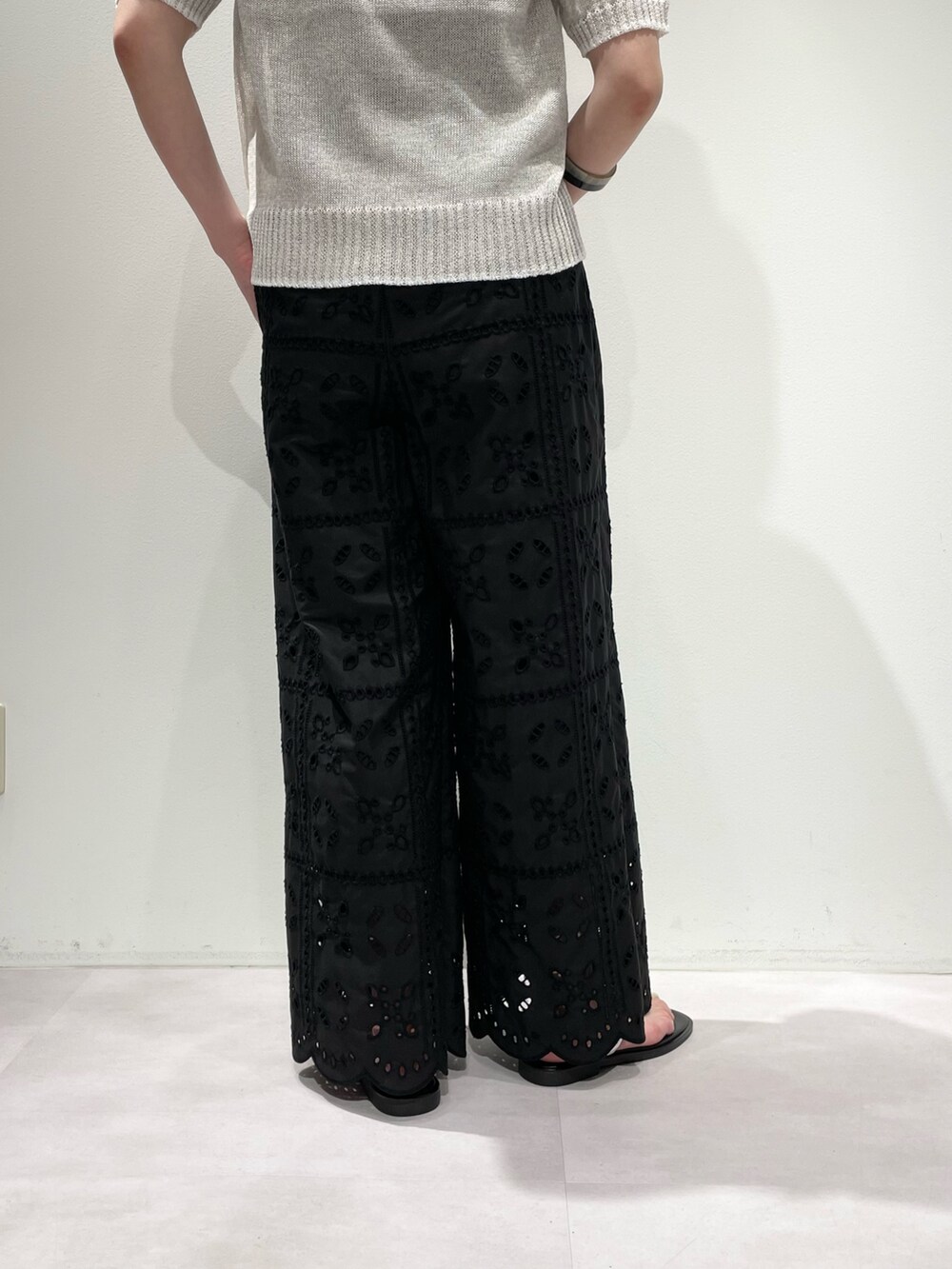 ブラック系のその他パンツ、ホワイト系のニット/セーター、ホワイト系のネックレスを着用したレディースの春コーディネートの9枚目の写真