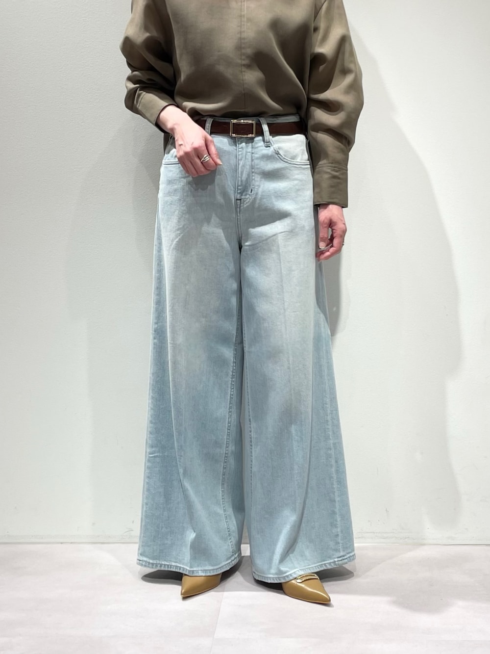 グリーン系のシャツ/ブラウス、ブルー系のデニムパンツ、ブラウン系のベルトを着用したレディースの冬コーディネートの7枚目の写真