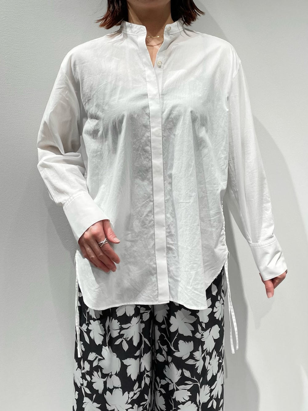 グレー系のその他パンツ、ホワイト系のニット/セーター、ゴールド系のネックレスを着用したレディースの冬コーディネートの7枚目の写真