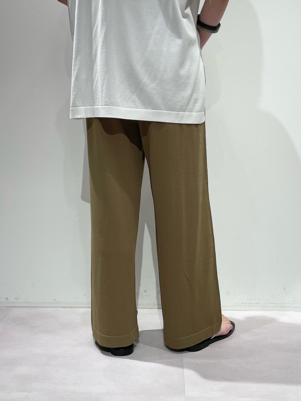 ベージュ系のその他パンツ、ホワイト系のニット/セーター、ブラック系のネックレスを着用したレディースの夏コーディネートの9枚目の写真