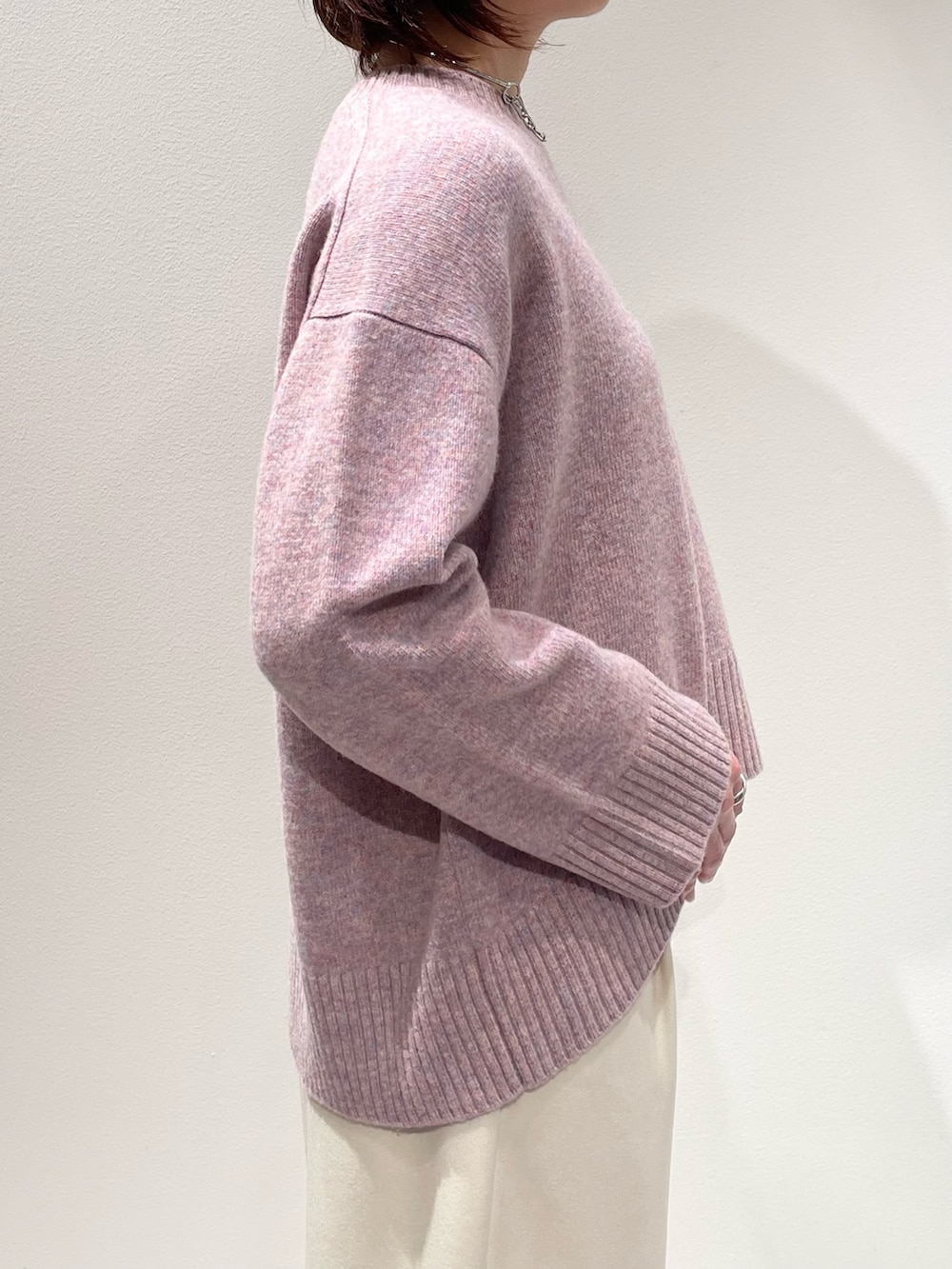 ピンク系のニット/セーター、ホワイト系のその他パンツ、シルバー系のネックレスを着用したレディースの冬コーディネートの5枚目の写真