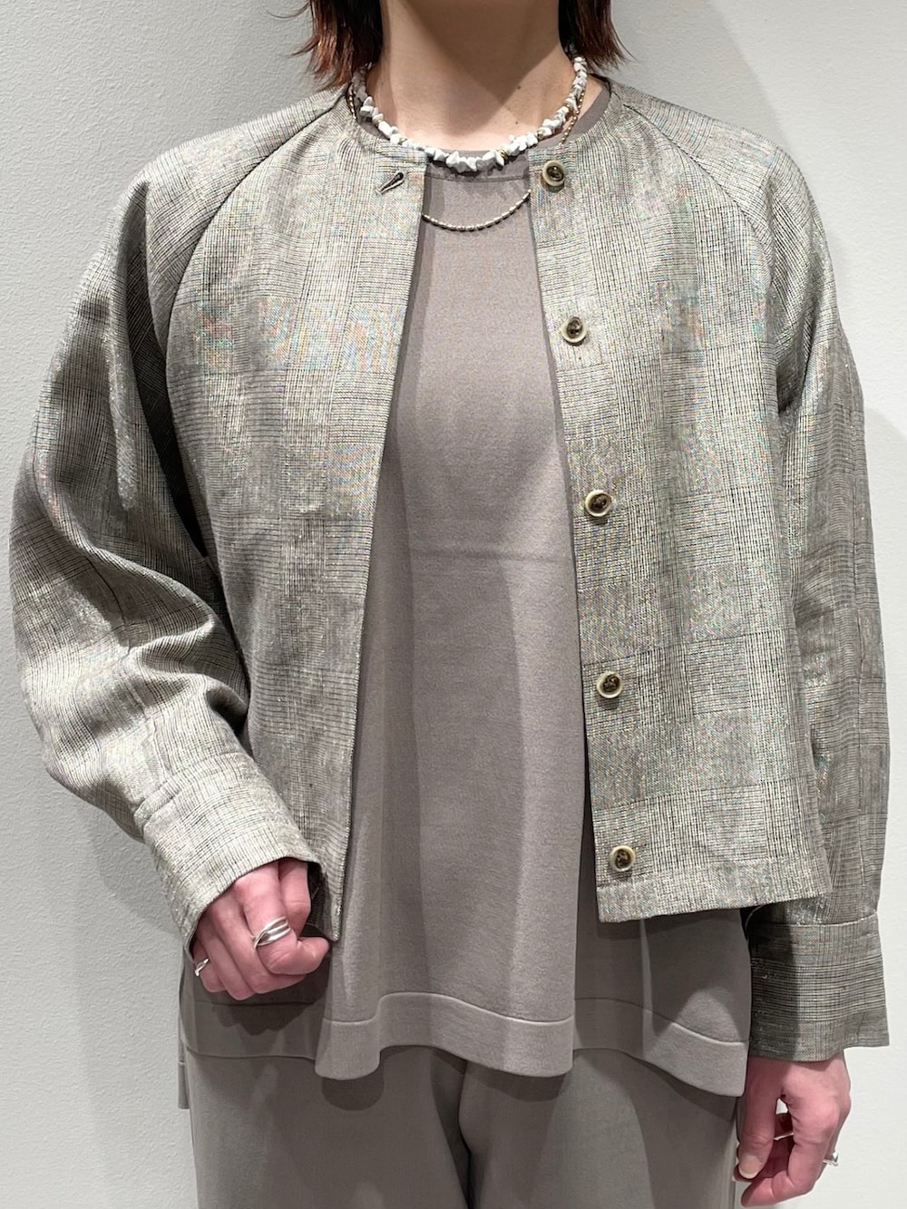 グレー系のニット/セーター、グレー系のその他パンツ、ベージュ系のブルゾンを着用したレディースの春コーディネートの4枚目の写真