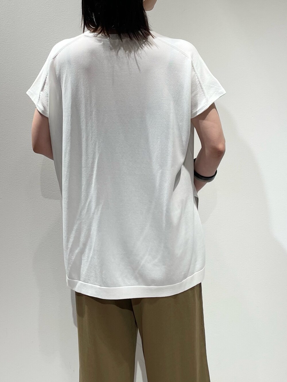 ベージュ系のその他パンツ、ホワイト系のニット/セーター、ブラック系のネックレスを着用したレディースの夏コーディネートの6枚目の写真