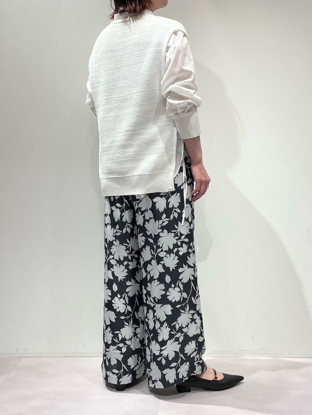 グレー系のその他パンツ、ホワイト系のニット/セーター、ゴールド系のネックレスを着用したレディースの冬コーディネートの3枚目の写真