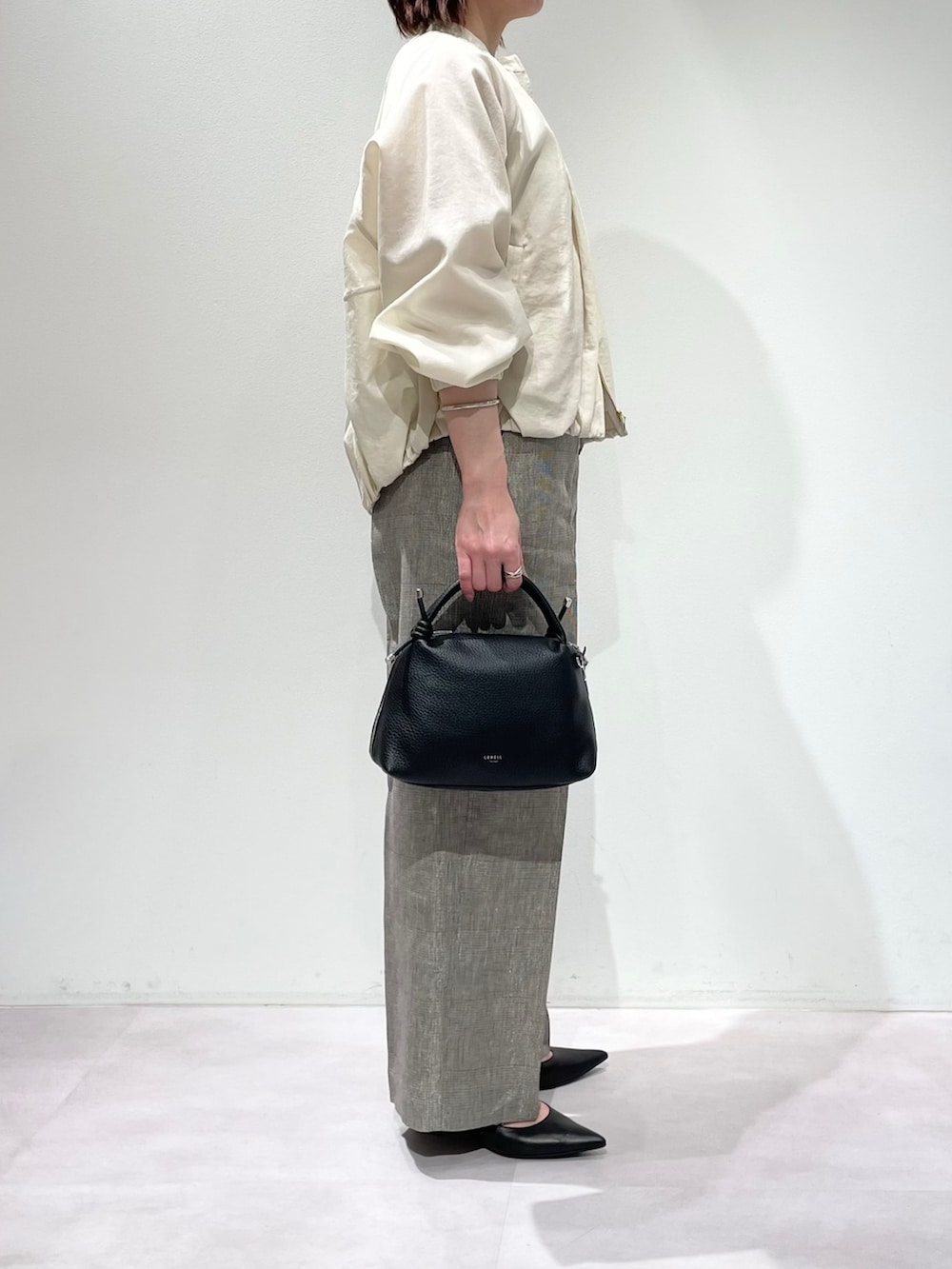 ホワイト系のタンクトップ、ホワイト系のブルゾン、ベージュ系のその他パンツを着用したレディースの春コーディネートの2枚目の写真