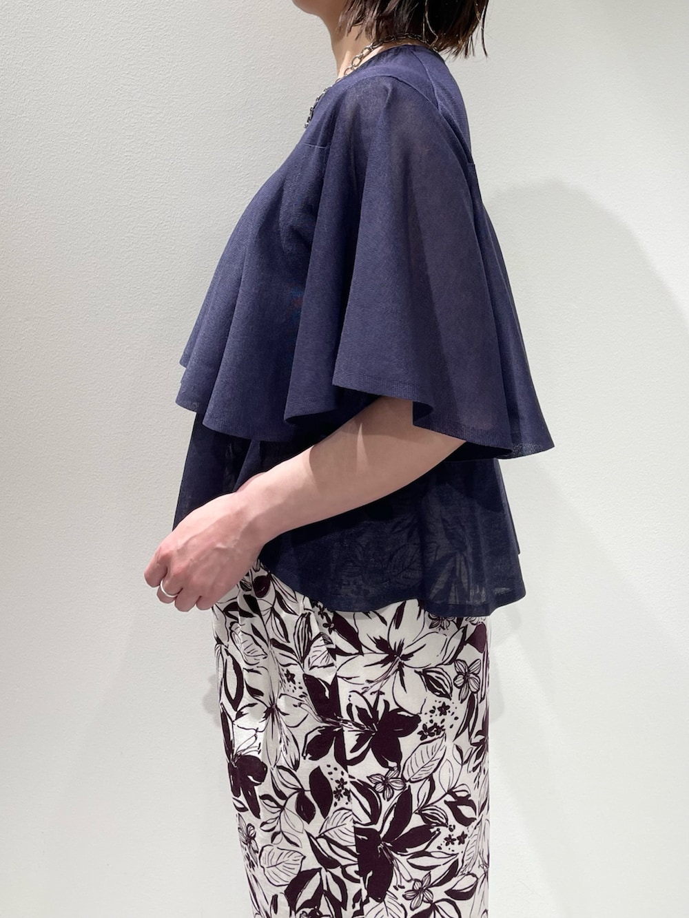 レッド系のその他パンツ、ブルー系のニット/セーター、シルバー系のネックレスを着用したレディースの春コーディネートの5枚目の写真