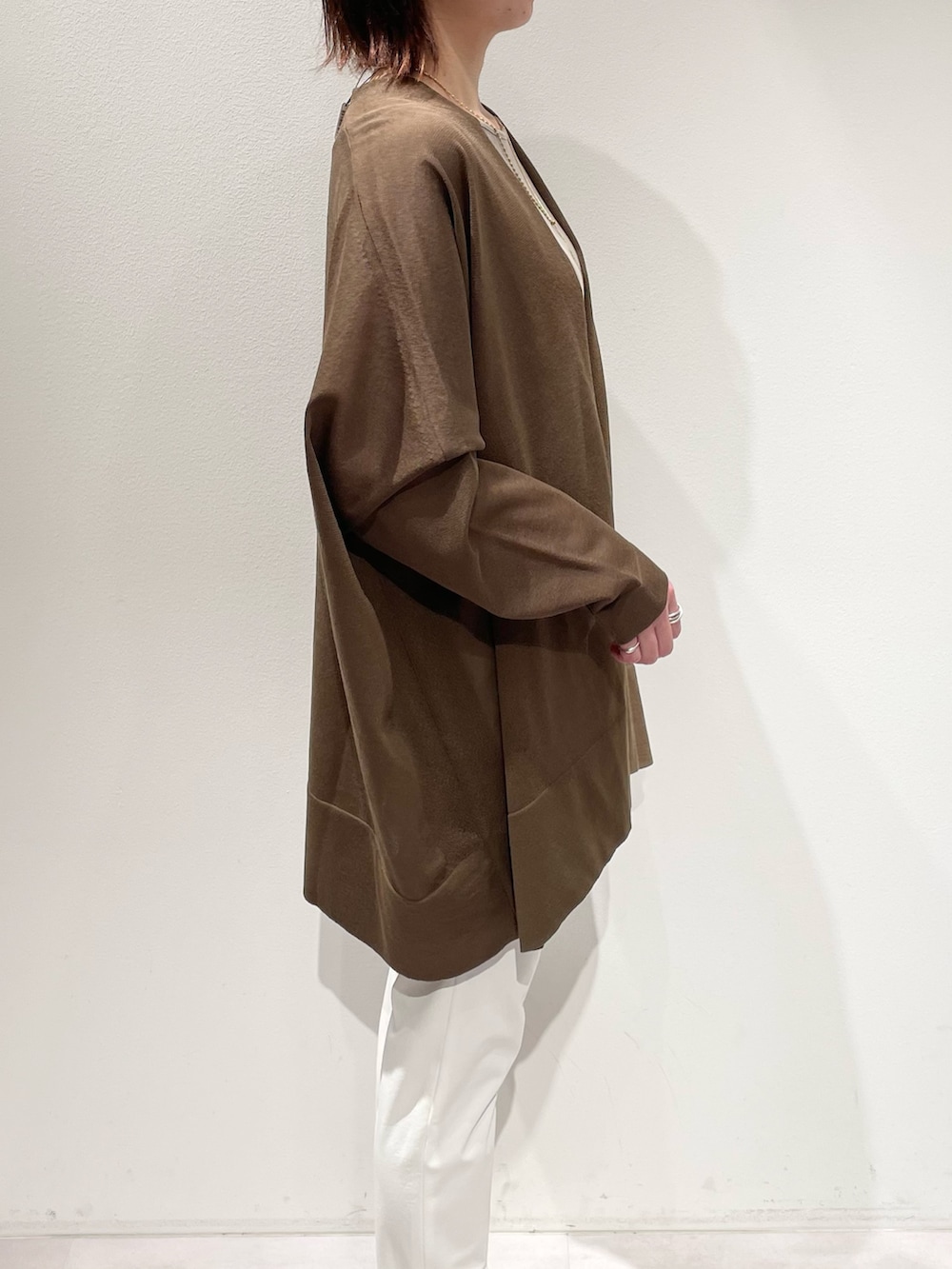 グリーン系のシャツ/ブラウス、ベージュ系のタンクトップ、ホワイト系のその他パンツを着用したレディースの春コーディネートの5枚目の写真