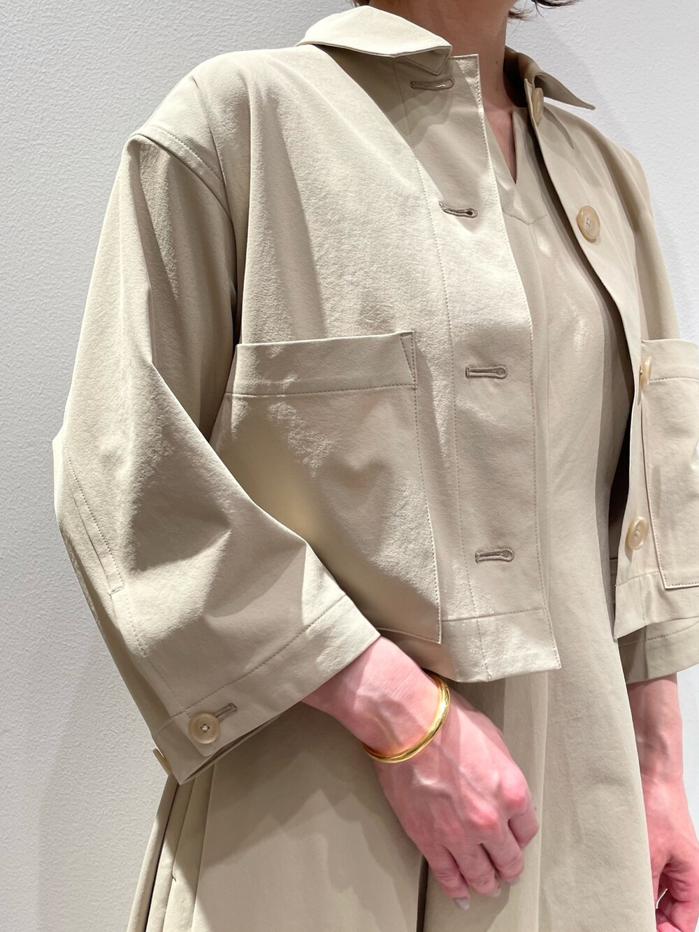 ベージュ系のトートバッグ、ベージュ系のワンピース、ベージュ系のブルゾンを着用したレディースの春コーディネートの5枚目の写真