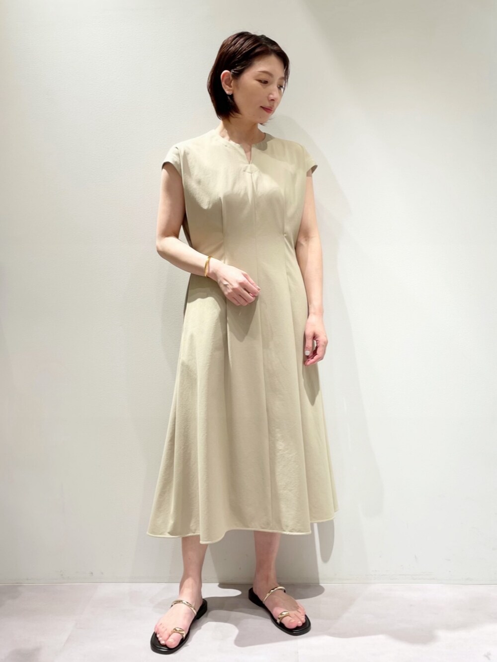 ベージュ系のトートバッグ、ベージュ系のワンピース、ベージュ系のブルゾンを着用したレディースの春コーディネートの2枚目の写真