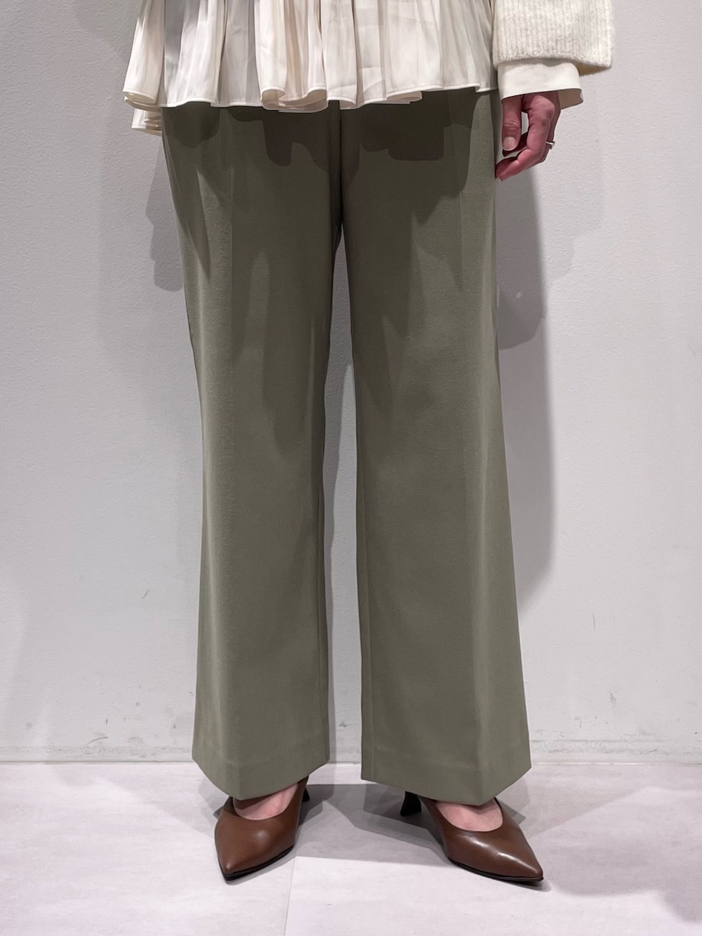 ホワイト系のニット/セーター、ホワイト系のシャツ/ブラウス、グリーン系のその他パンツを着用したレディースの秋コーディネートの7枚目の写真