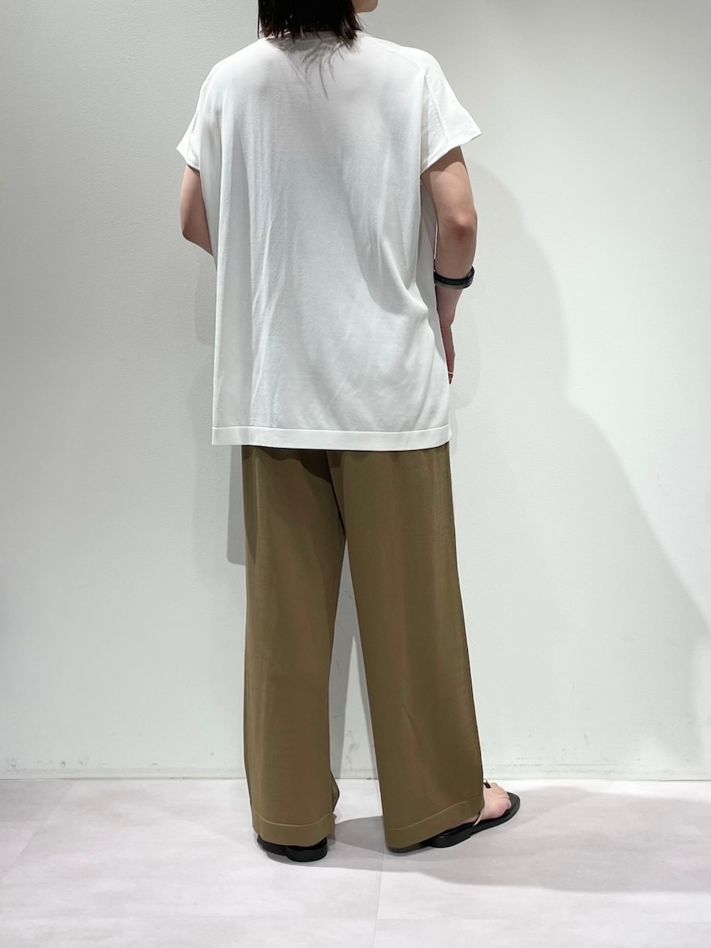 ベージュ系のその他パンツ、ホワイト系のニット/セーター、ブラック系のネックレスを着用したレディースの夏コーディネートの3枚目の写真