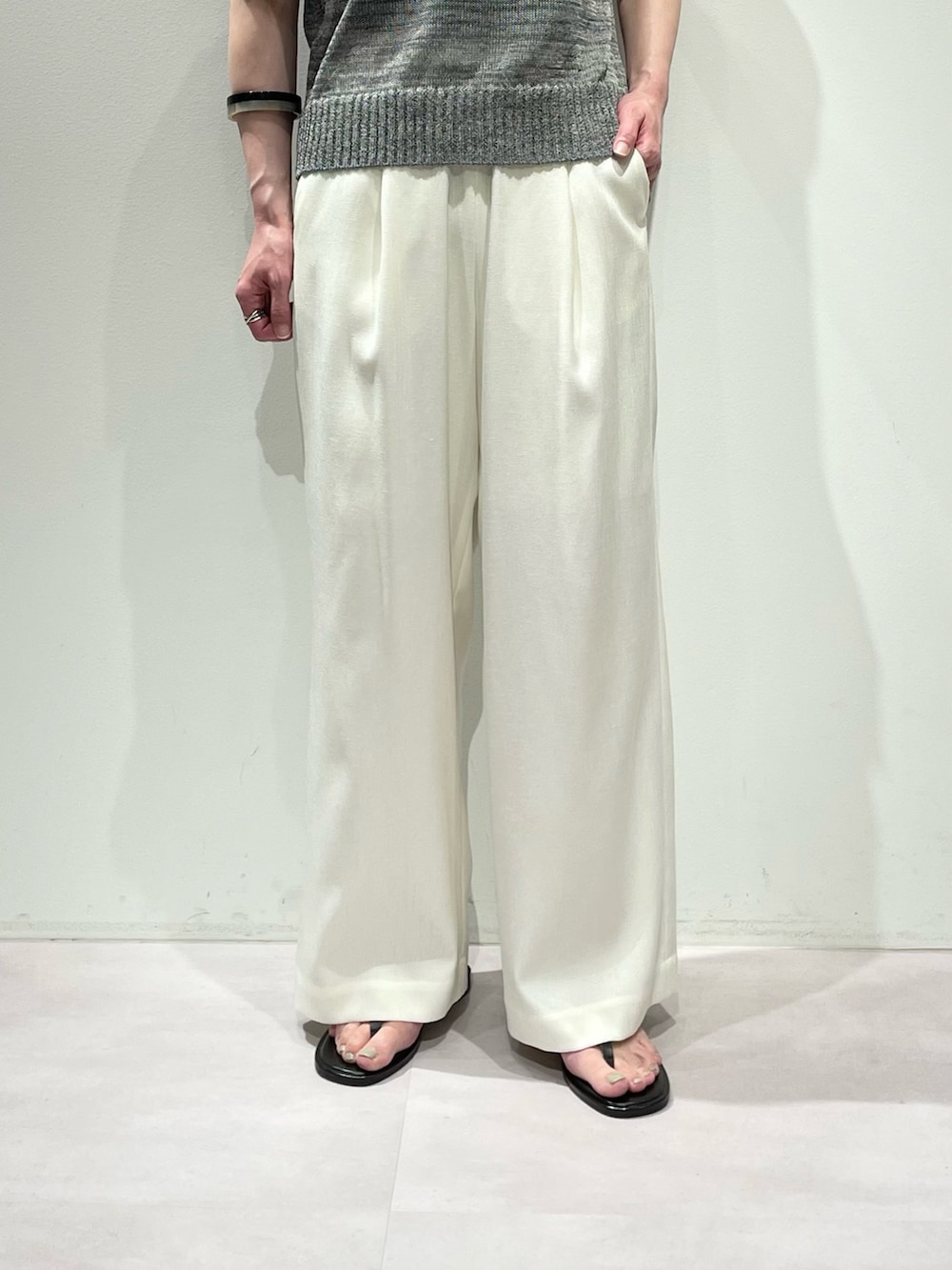 グレー系のニット/セーター、ホワイト系のその他パンツ、ブラウン系のサンダルを着用したレディースの夏コーディネートの7枚目の写真
