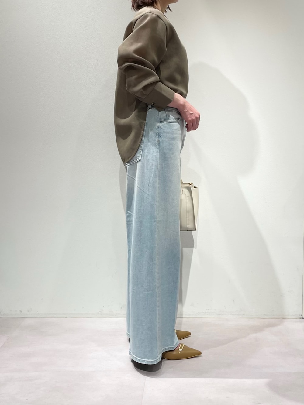 グリーン系のシャツ/ブラウス、ブルー系のデニムパンツ、ブラウン系のベルトを着用したレディースの冬コーディネートの2枚目の写真