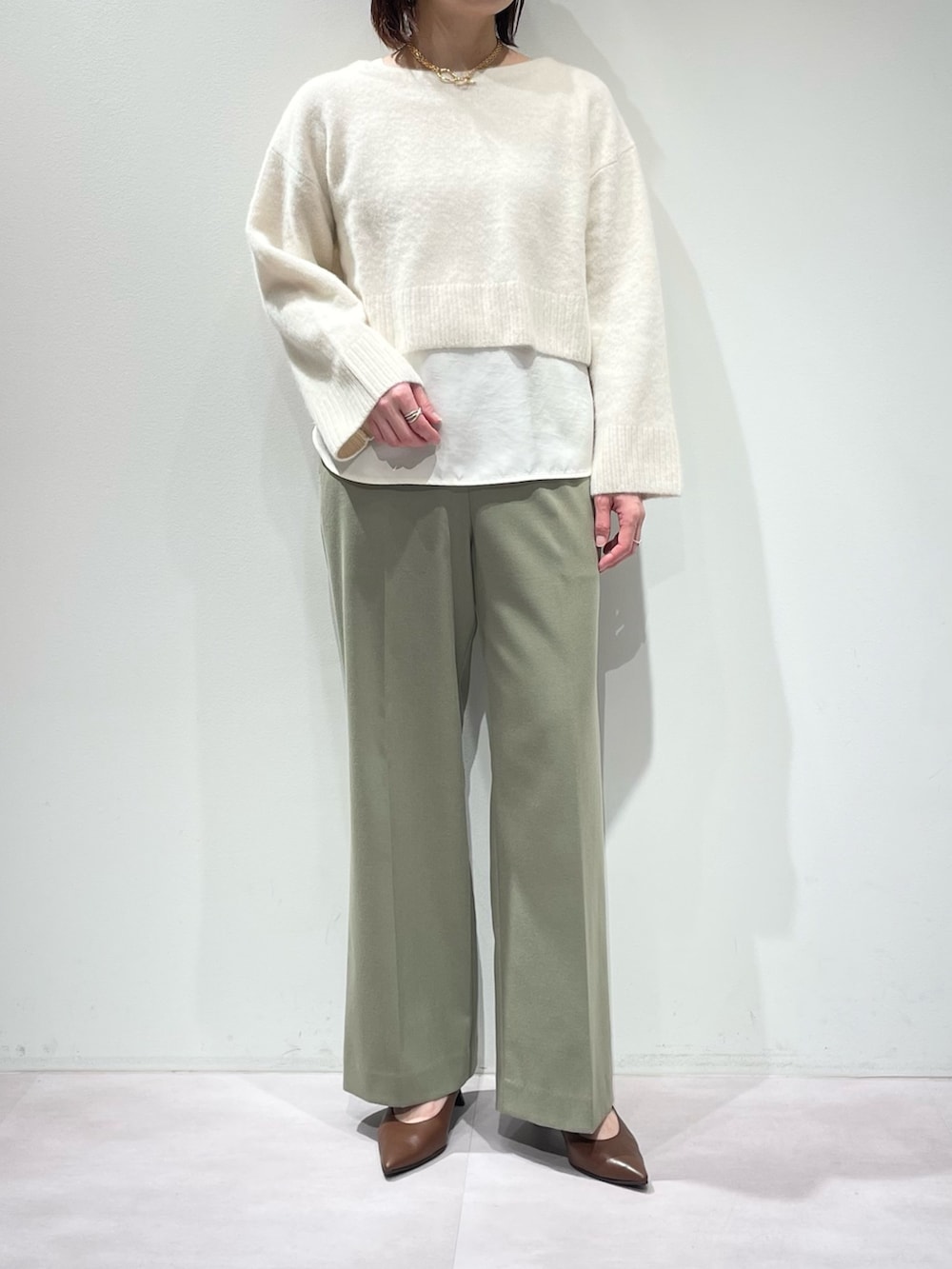 グリーン系のその他パンツ、ホワイト系のニット/セーター、ホワイト系のタンクトップを着用したレディースの冬コーディネートの7枚目の写真