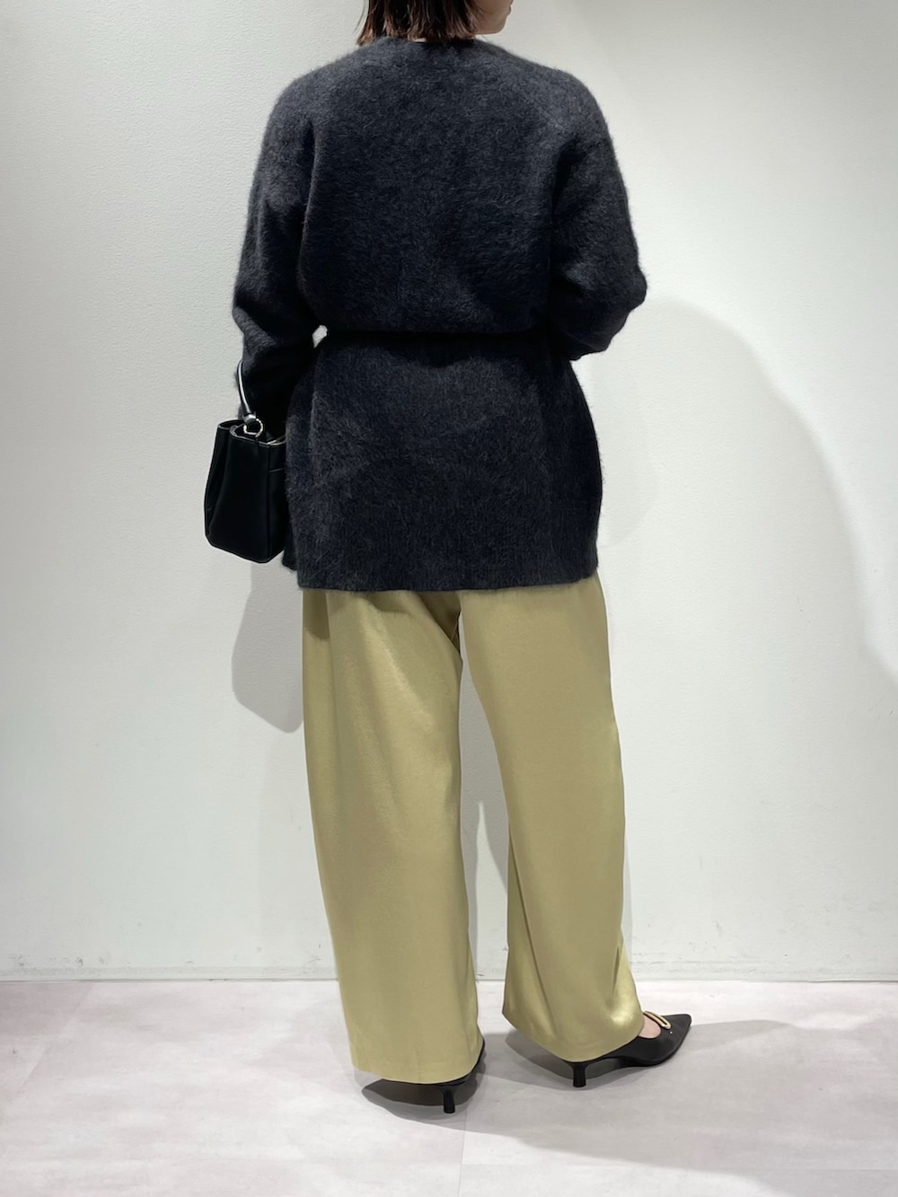 イエロー系のその他パンツ、グレー系のカーディガン/ボレロ、ホワイト系のTシャツ/カットソーを着用したレディースの秋コーディネートの3枚目の写真