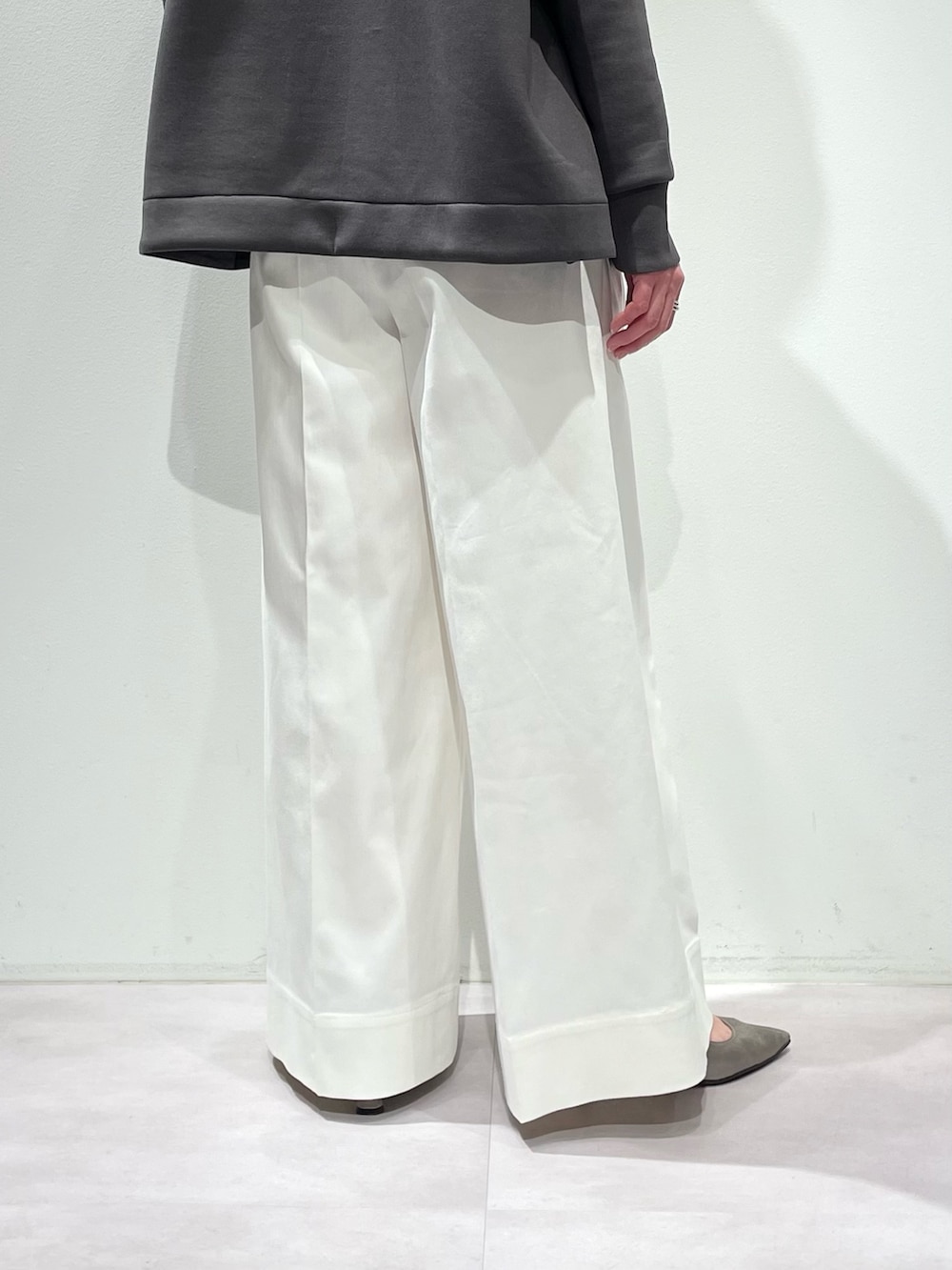 グレー系のスウェット、ホワイト系のデニムパンツ、シルバー系のネックレスを着用したレディースの冬コーディネートの9枚目の写真