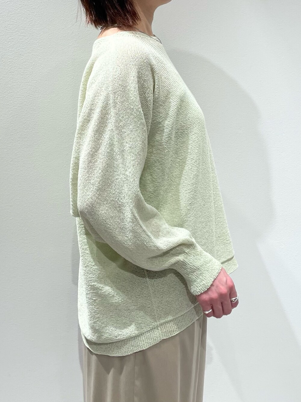 グリーン系のニット/セーター、ベージュ系のその他パンツ、シルバー系のネックレスを着用したレディースの春コーディネートの5枚目の写真