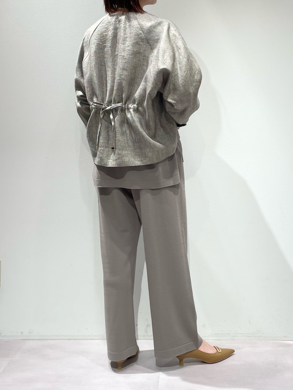 グレー系のニット/セーター、グレー系のその他パンツ、ベージュ系のブルゾンを着用したレディースの春コーディネートの3枚目の写真